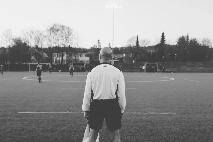 Tilskuer følger en lokal amatørkamp fra sidelinjen